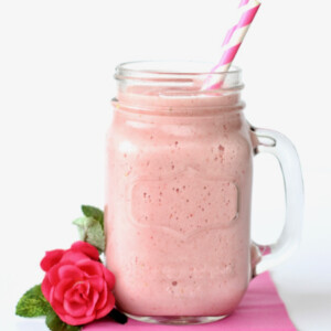 Strawberry drink in a jar with paper straws.