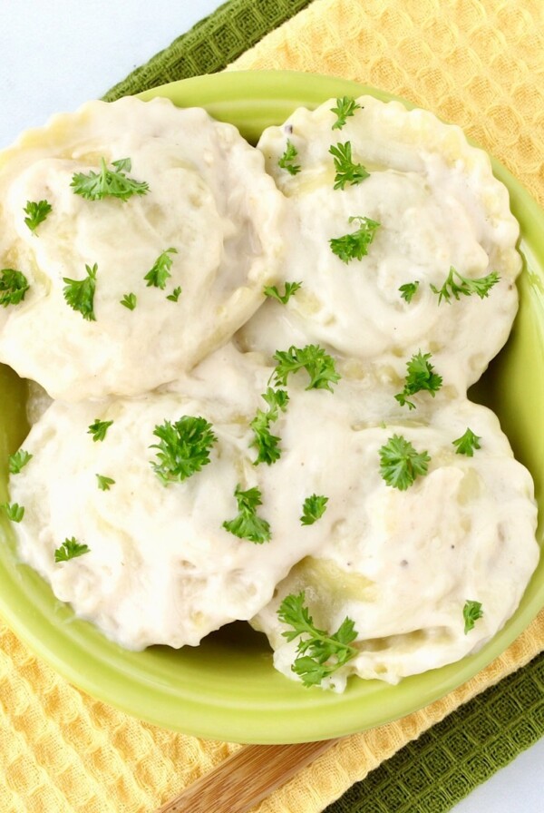 Green bowl of Alfredo Ravioli.