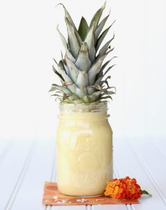 Pineapple top on a jar of smoothie.