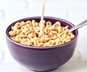 Vanilla oat milk pouring into a bowl of cereal.