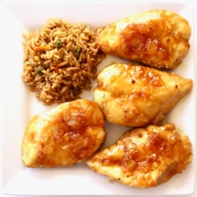 Mandarin chicken on a plate with rice.