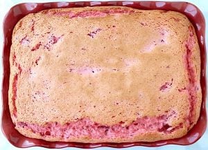 Strawberry angel food cake in red baking dish.