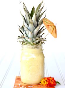 Pineapple top on a jar of smoothie.