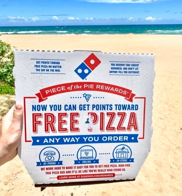 Person holding a Domino's pizza box.