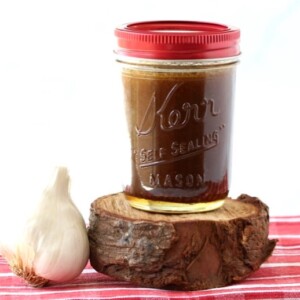 Jar of Honey Balsamic Dressing Recipe with a bulb of garlic.