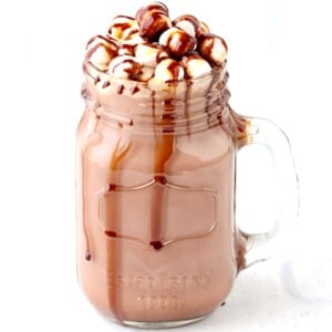 Jar of hot chocolate with chocolate syrup dripping down the side.