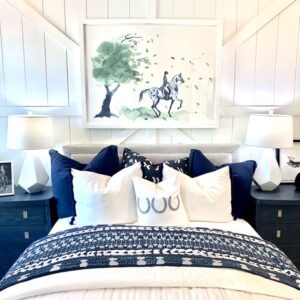 Painting of a horse and tree over a blue and white bed.