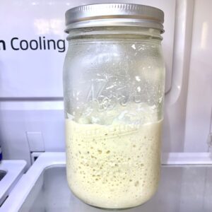 Jar half filled with sourdough starter.