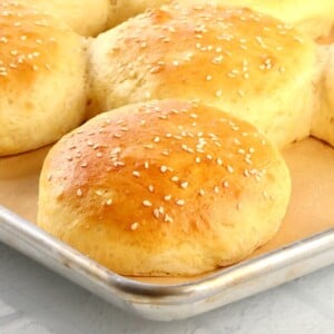 Homemade Hamburger Buns on a lined baking sheet.