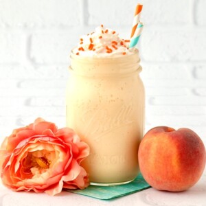 Peach Milkshake in a jar with a peach and a flower.