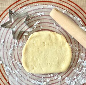Disc of cookie dough with a rolling pin.