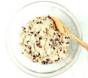 Spoon in a bowl with cranberry walnut bread dough.