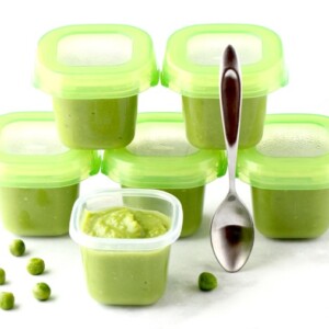 Several containers of homemade baby food peas.