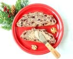 Cinnamon butter being spread on cranberry walnut bread.