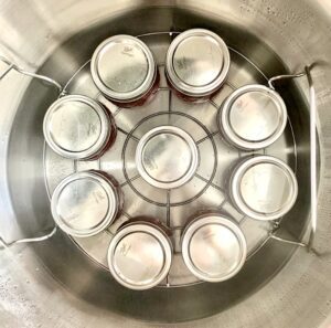 Water bath with jars of raspberry jam.