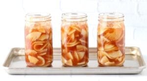 Uncovered jars of apple pie filling.