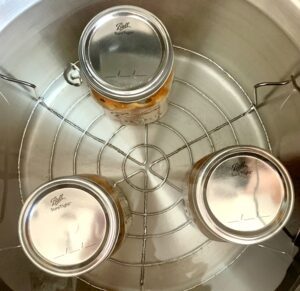 Jars of apple pie filling in a water bath.