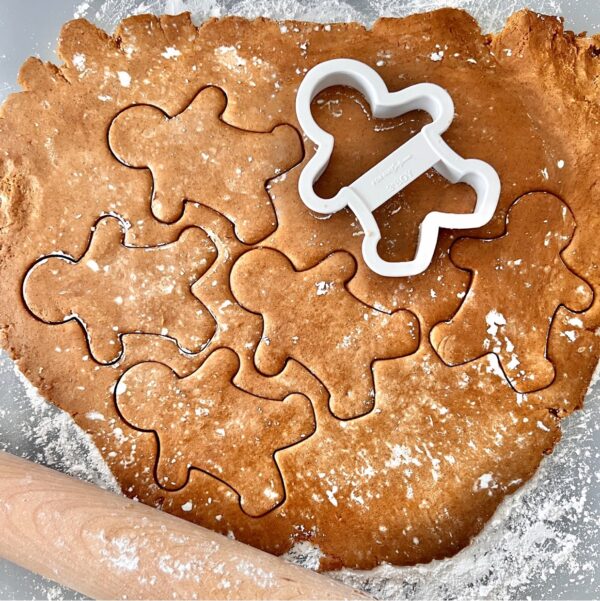 Gingerbread cookies dough with gingerbread man cookie cutter.