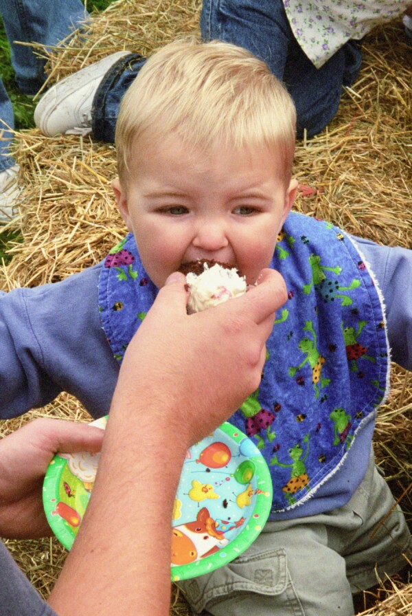 Person feeding food to a child.