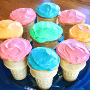 Blue plate filled with colorful ice cream cone cupcakes.