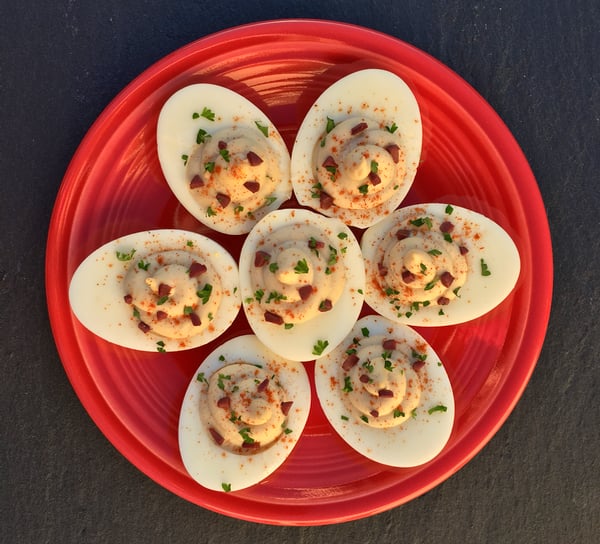 Mediterranean Deviled Eggs with hummus on plate.