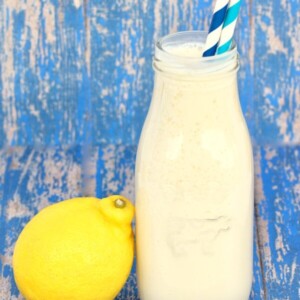 Frosted Lemonade in a glass bottle with a lemon.