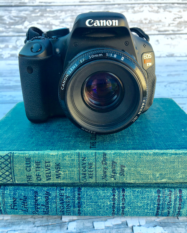 DSLR camera on stack of books.