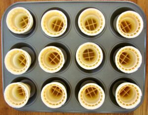Empty ice cream cones in cupcake pan.