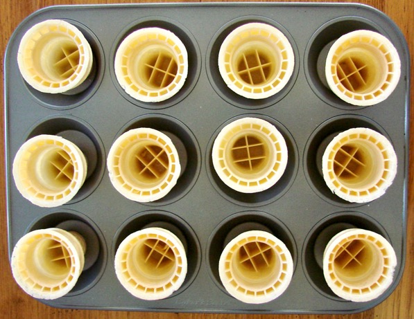 Empty ice cream cones in cupcake pan.