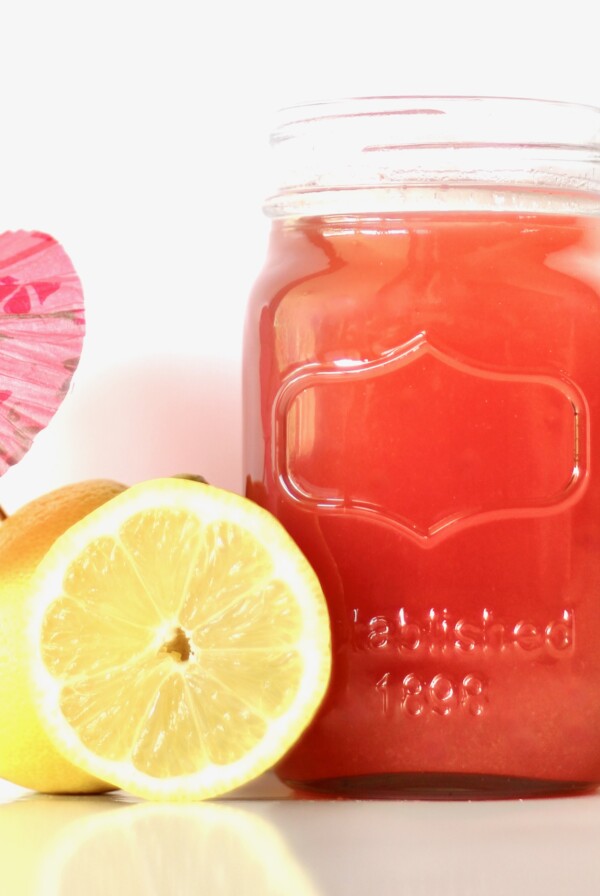 Pineapple Pink Lemonade Party Punch in a jar next to lemons.