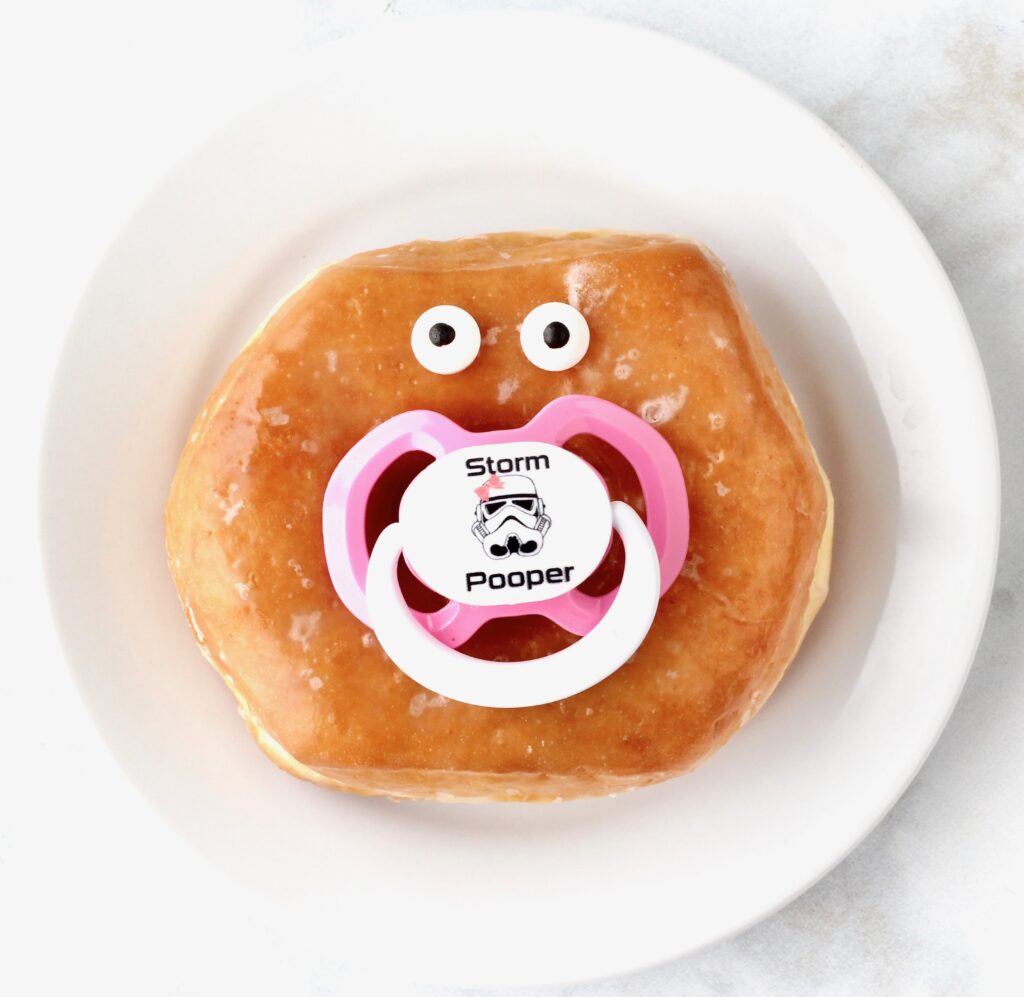 Donut with a pink pacifier with text \"Storm Pooper.\"