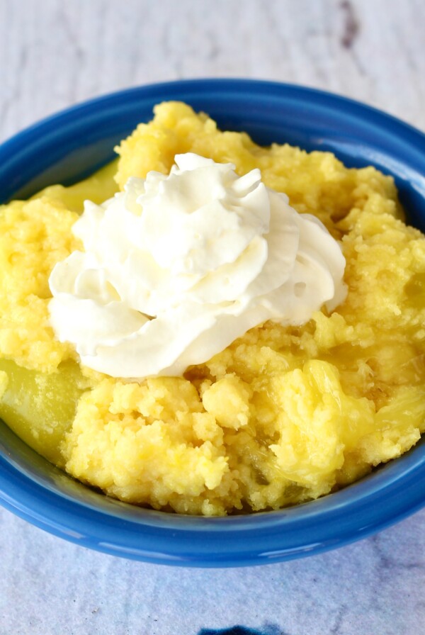 Lemon Dump Cake topped with whipped cream.