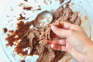 Person holding thick brownie batter.