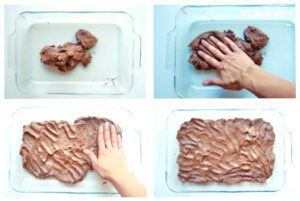 Person patting brownie batter into a pan.