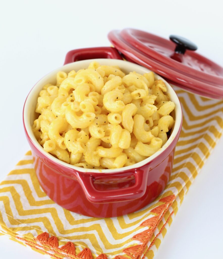 Macaroni and cheese in a small red crock.