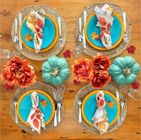 Thanksgiving Table Settings with flowers and blue pumpkins.