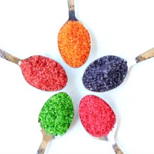 Homemade colored sugar sprinkles on 5 different spoons.