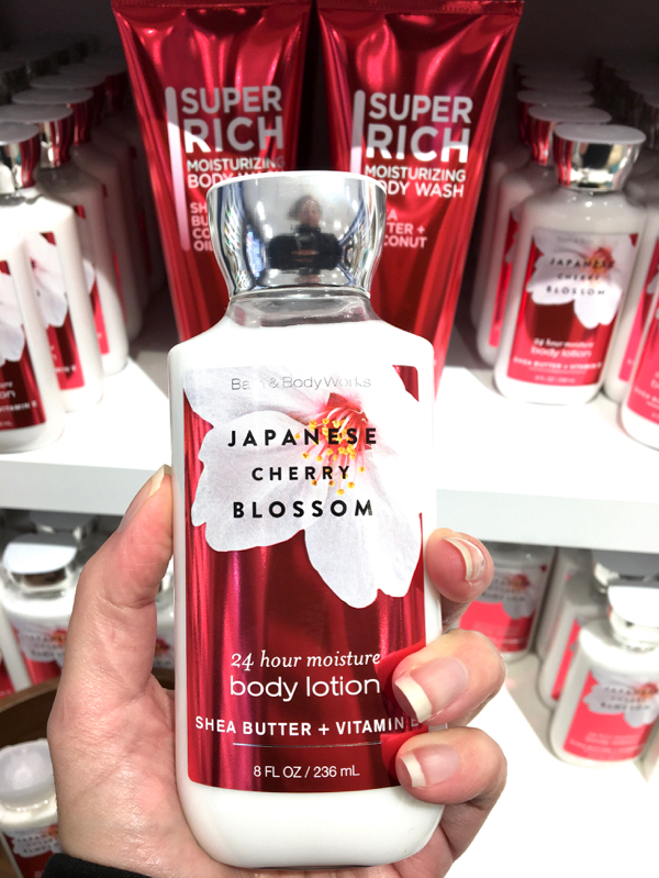 Person holding Bath and Body Works Japanese Cherry Blossom lotion.