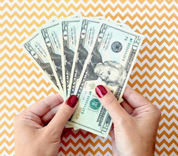 Hands holding twenty dollar bills.