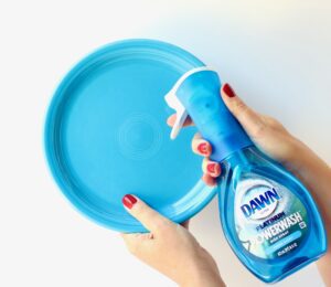 Person spraying Dawn Powerwash on a plate.
