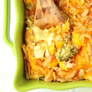 Wooden spoon scooping Chicken Broccoli Rice Casserole.