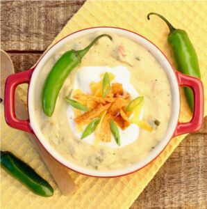 Bowl of chicken enchilada soup topped with a pepper.