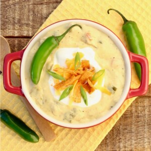 Bowl of chicken enchilada soup topped with a pepper.