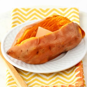 Cut sweet potato with butter on a plate.