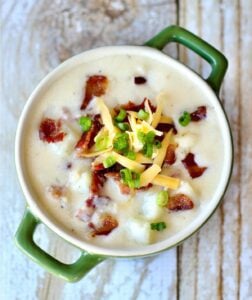 Cheese and bacon on a bowl of potato soup.