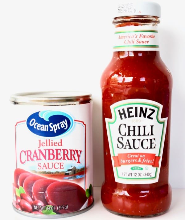 Can of jellied cranberry sauce and bottle of chili sauce.