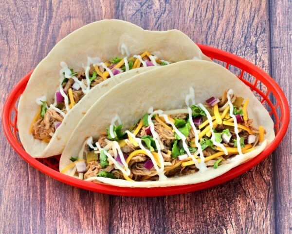 Two Pulled Pork Tacos in a red basket.