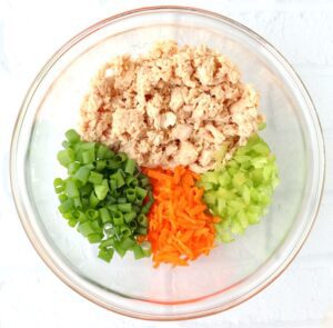 Unmixed salmon sandwich ingredients in a glass bowl.