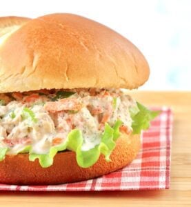 Salmon Sandwich on a bun sitting on a cloth napkin.