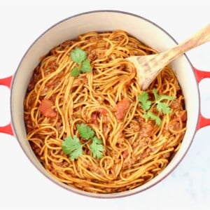 Wooden spoon in a Dutch oven of Taco Spaghetti.